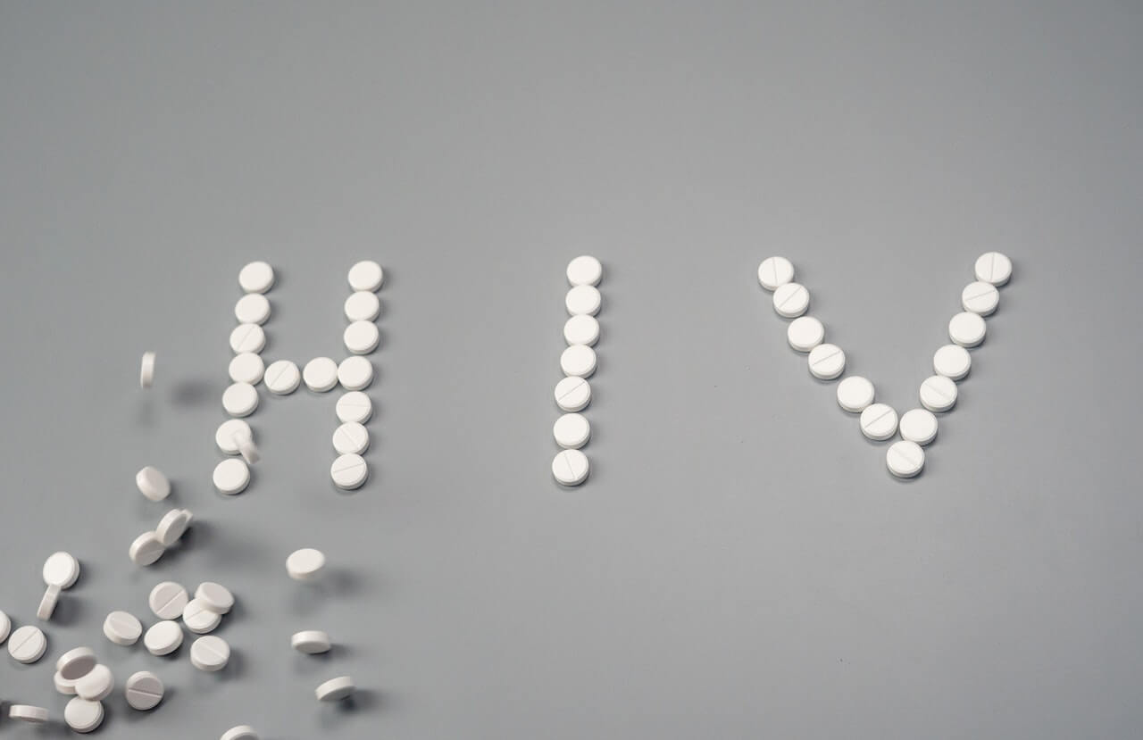Imagen de la palabra VIH deletreada en el suelo con pastillas